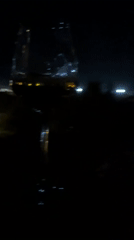 Drinks on a balcony overlooking Makarska's lit-up harbor at night
