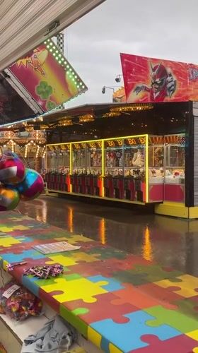 Rainy night at a Varna amusement park, rides and game stalls