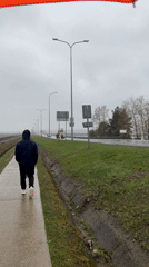 Couple documents rainy morning walk along Chaikovsky railway tracks