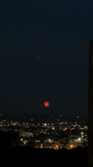 Red moon rises over Lyubertsy city lights