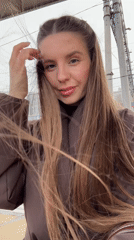 Woman photographs herself at train station in Klin, Russia