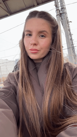 Woman photographs herself at train station in Klin, Russia