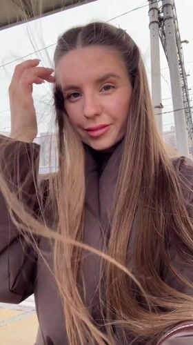 Woman photographs herself at train station in Klin, Russia