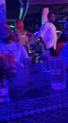 Bar patrons captured during evening hours amid colorful lighting