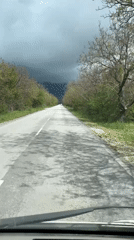 Storm clouds gather over wet road in Dabene, Bulgaria