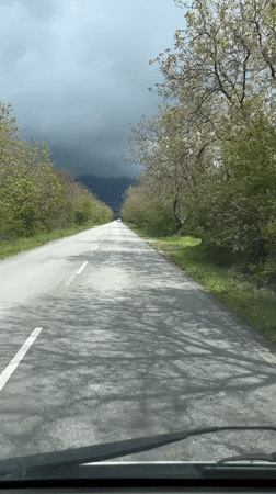 Storm clouds gather over wet road in Dabene, Bulgaria