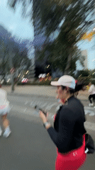 Marathon runners in red shirts race through Mexico City streets
