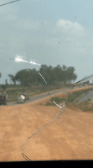 Vehicle journey documented through cracked windshield in Dokwa, Nigeria
