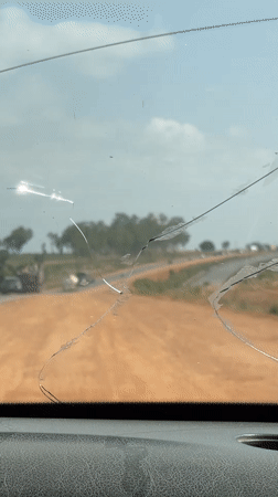 Vehicle journey documented through cracked windshield in Dokwa, Nigeria