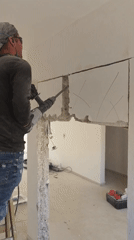 Construction worker demolishes interior wall in Bat Yam building