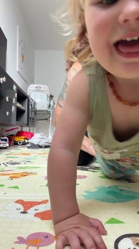 Toddler crawls on floor mat in Kiryat Bialik home