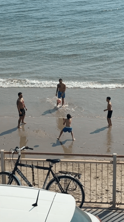 Beachgoers enjoy sunny afternoon recreational activities in Sanremo, Italy