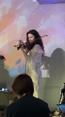 Live duo performance with violin, guitar, and projected visuals in Moscow
