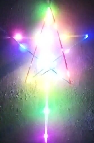 Colorful star-shaped LED structure glowing on a wall in Indonesia