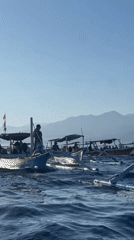Passenger boats with life-vested travelers navigate Indonesian waters