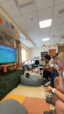 England fans watch a soccer match with face paint and flags