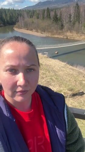 Woman documents scenic river valley views in Kordonnyi, Russia