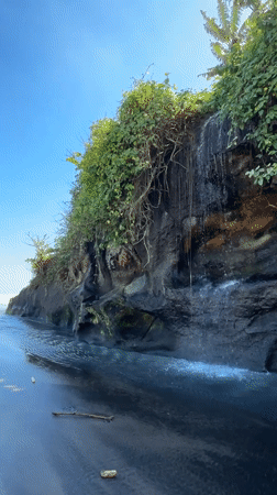 Waterfall meets black sand at Yeh Gangga Beach, Bali