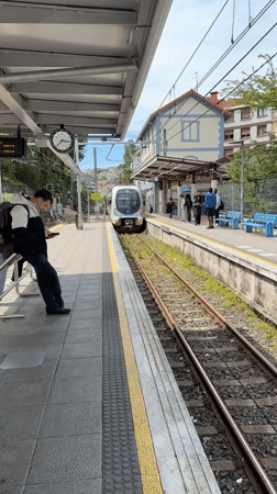 Train arrives at Errenteria station, passenger waits on platform