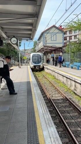 Train arrives at Errenteria station, passenger waits on platform