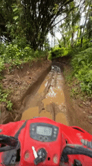 Red ATV navigates muddy terrain in Abiansemal, Indonesia