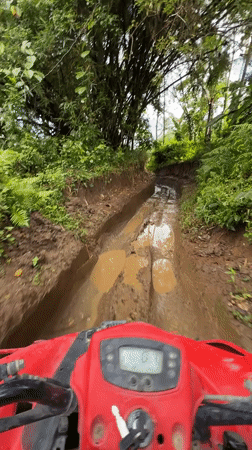 Red ATV navigates muddy terrain in Abiansemal, Indonesia