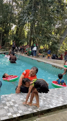 Crowded outdoor pool day at a green recreation spot in Java