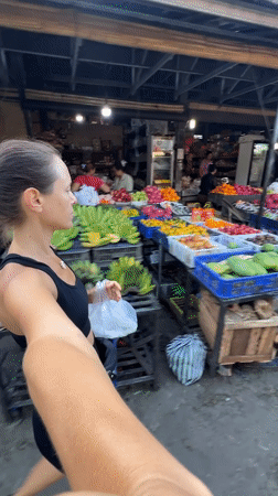 Tourist documents vibrant market visit in Ubud, Indonesia
