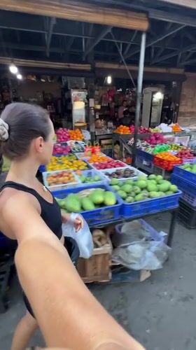 Tourist documents vibrant market visit in Ubud, Indonesia