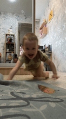 Toddler crawls playfully across floor in Russian home