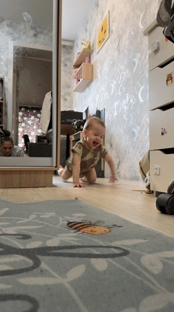 Toddler crawls playfully across floor in Russian home