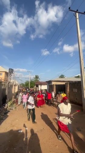 Community parade observed on dirt road in Lokoja
