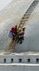 Man installs prayer flags near busy Buddhist temple in Kathmandu