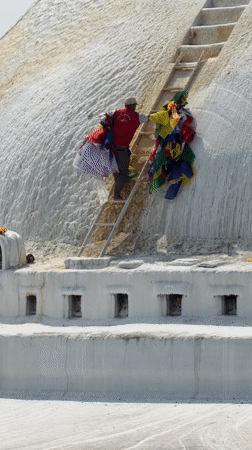 Man installs prayer flags near busy Buddhist temple in Kathmandu