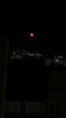 Orange supermoon rises over Odesa skyline on summer night