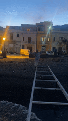 Person stands on metal structure at Lipari beach dusk