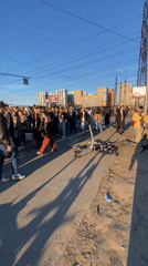 Large pedestrian group crosses street in Murino, Russia