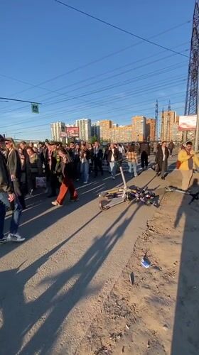 Large pedestrian group crosses street in Murino, Russia