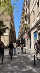 Skateboarder navigates narrow European street on sunny afternoon
