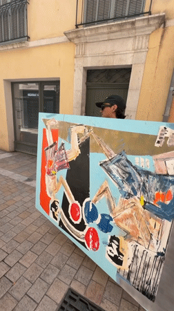 Person carries abstract painting through Toulon street