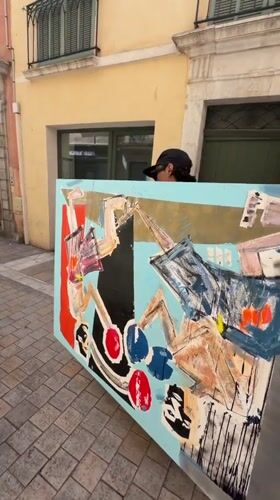 Person carries abstract painting through Toulon street