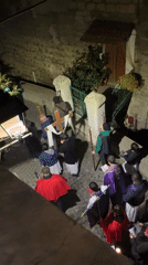 Religious procession winds through historic Italian town at night