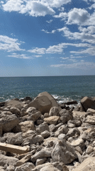 Person stands on rocky Adriatic cliffs in Montenegro