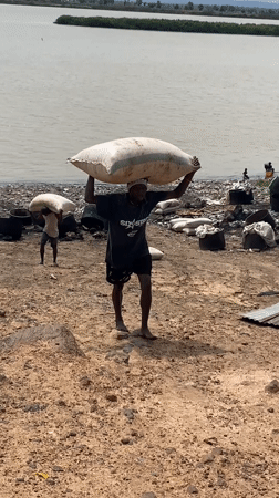 Workers transport sacks near waterway in Lokoja, Nigeria
