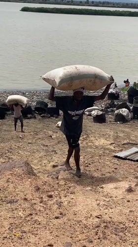 Workers transport sacks near waterway in Lokoja, Nigeria