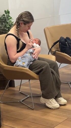 Woman bottle-feeds baby in Coquitlam waiting area