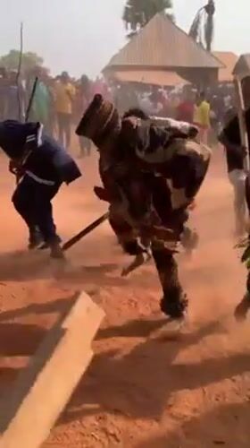Traditional masked dancers perform stick dance in Aka, Nigeria