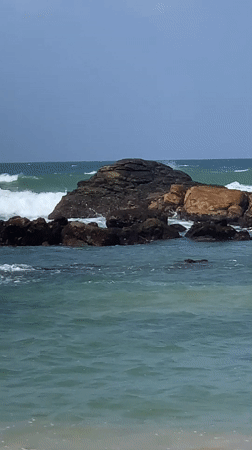 Midigama's rocky coastline and offshore island on a cloudy morning