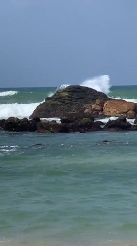 Midigama's rocky coastline and offshore island on a cloudy morning