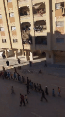 Children walk in supervised group through Khan Yunis streets